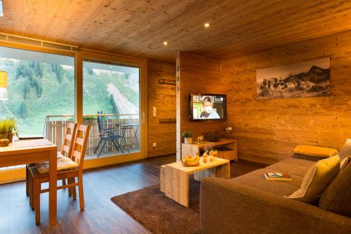 a living room with a couch and a table at Damülser Holzhus in Damuls