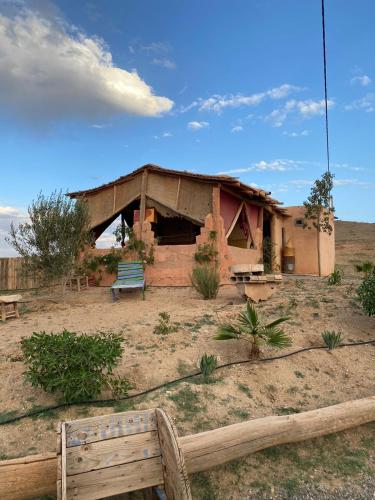 a building in the desert with a bench in front of it at Les cavaliers chez Yassine in Marrakech