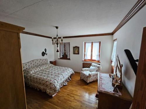 a bedroom with a bed and a chair at Casa Aurine di Zaccaria in Frassenè