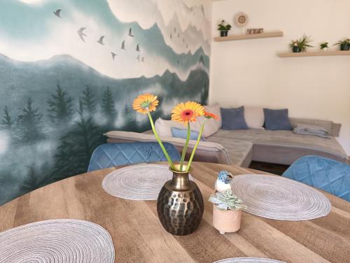 a vase with flowers on a wooden table at Sophia apartman Straßburg Kärnten in Straßburg in Kärnten