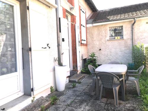 un patio avec une table et des chaises à côté d'un bâtiment dans l'établissement MAISON CHOLLET - Centre - Prox. Thermes - Terrasse, à Vichy