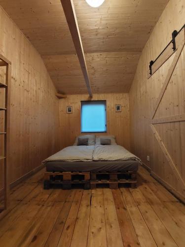 ein Schlafzimmer mit einem Bett in einem Holzzimmer in der Unterkunft BaTerka in Česká Lípa