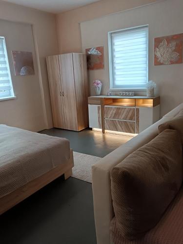 a bedroom with a bed and a desk and a couch at Apartman ClaRa in Štúrovo