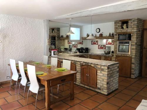 - une cuisine avec une table en bois et des chaises blanches dans l'établissement Villa piscine entre lac et montagne, à Grésy-sur-Aix
