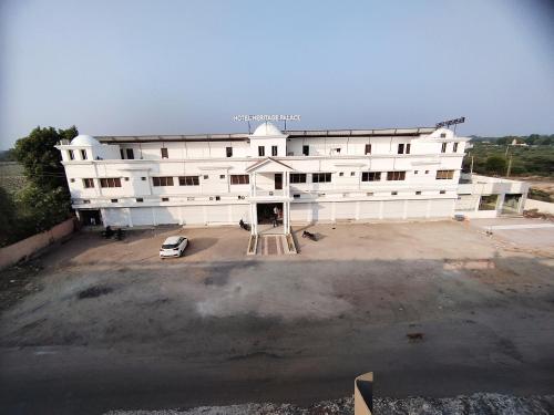 a large white building with a car in front of it at Heritage Palace - Bhuj in Bhuj