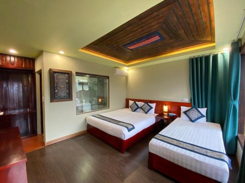 a hotel room with two beds and a window at Botanic Sapa Hotel in Sa Pa