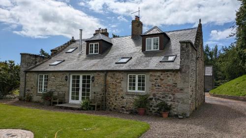 an old stone house with a roof at Cumledge Yew Trees Cottage in Duns
