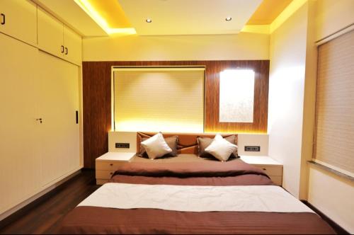 a bedroom with a large bed and a window at Classic Premium luxurious 3bhk fully furnished apartment in koregaon park in Pune