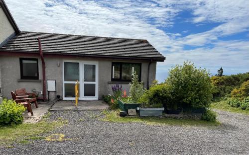 a small house with plants in front of it at The Stroops in Helmsdale