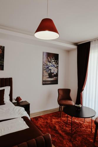 a bedroom with a bed and a couch and a table at Andoena Resort in Lipjan