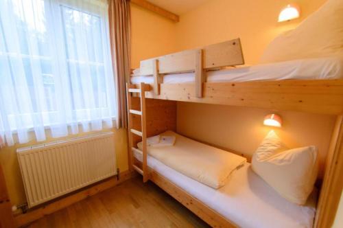 two bunk beds in a room with a window at JUFA Hotel Kaprun - Summercard included in Kaprun