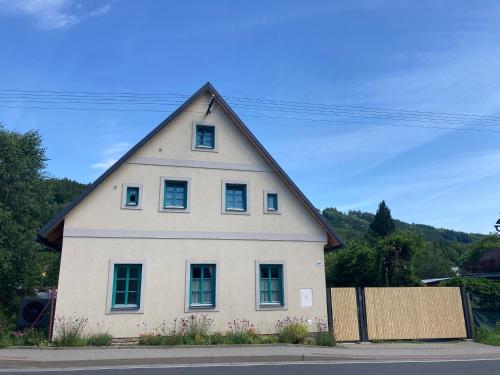 ein großes weißes Haus mit einem dreieckigen Dach in der Unterkunft Domek Kavalírek in Lipová-lázně