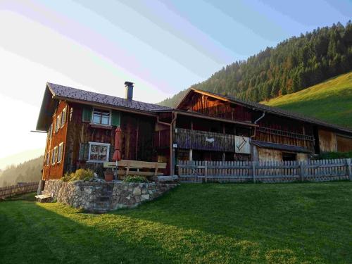 a large wooden house with a fence in a field at Haus Mura in Blons