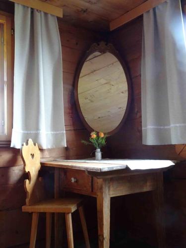 a dressing table in a cabin with a mirror and a chair at Haus Mura in Blons