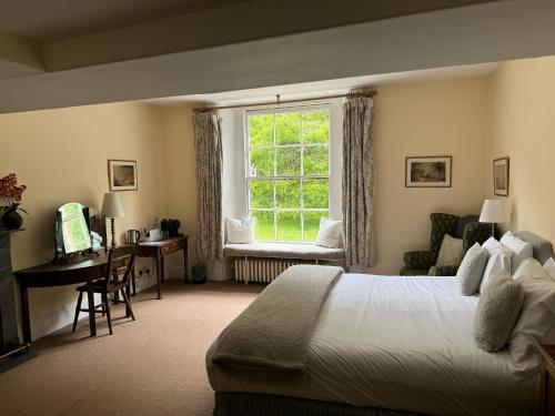 a bedroom with a bed and a window and a desk at Spread Eagle Inn in Stourton