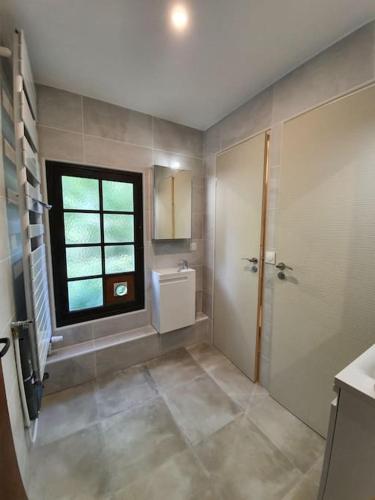 une salle de bain avec une douche et un lavabo et une fenêtre dans l'établissement French Cottage privé calme en bord de rivière, à Guérard