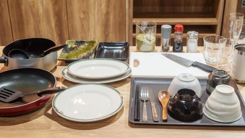 a table with plates and utensils on it at EIGHT POINT INN Kanazawa in Kanazawa