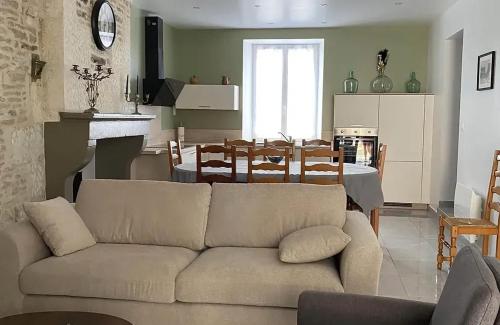 un salon avec un canapé et une salle à manger dans l'établissement Maison charmante aux Riceys avec cour extérieure, aux Riceys