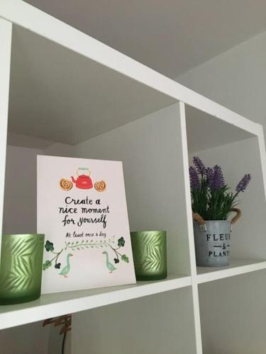 a shelf with three green cups and a sign on it at Moderne Ferienwohnung in Wismars Altstadt in Wismar