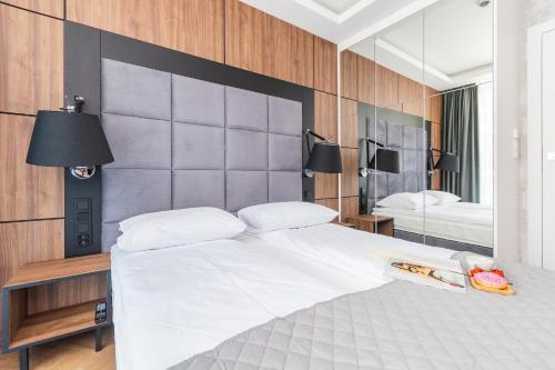una camera da letto con un grande letto bianco e uno specchio di Apartament Prywatny w Stegnie na ulicy Brzozowej 6 na I piętrze a Stegna