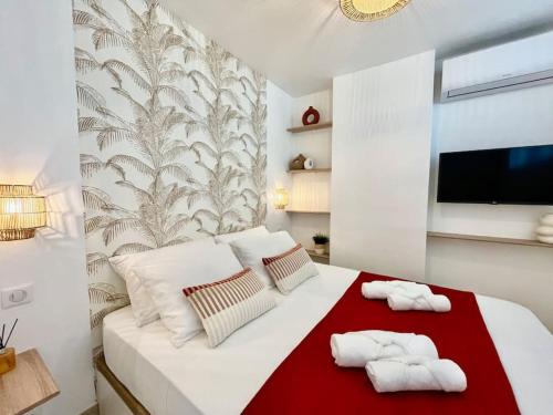 - une chambre avec un lit blanc et 2 serviettes dans l'établissement Magnifique T2 - Vue Mer - Parking - Juan-les-Pins, à Antibes