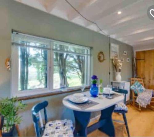 a kitchen with a table and chairs and a window at The Cabin at Bragdy in Pwllheli