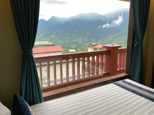 a bedroom with a balcony with a view of mountains at Botanic Sapa Hotel in Sa Pa