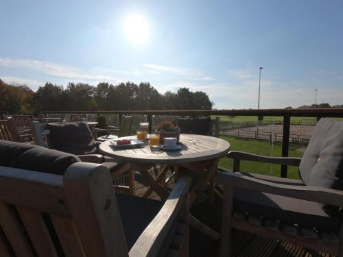 a table and two chairs on a deck with a table and a table at Human & Horse Hotel in Kootwijkerbroek