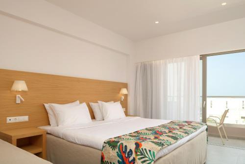 a hotel room with a bed and a large window at High Beach Resort in Malia