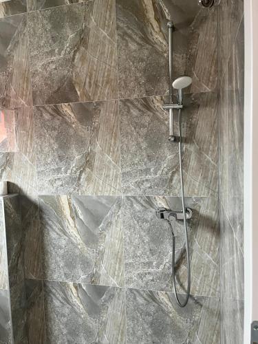 y baño con ducha y pared de piedra. en Villa Holiday, en Bihać