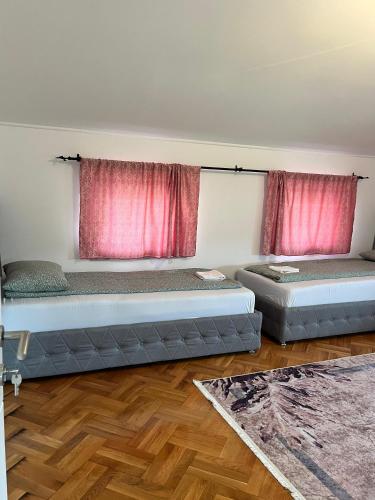 2 camas en una habitación con cortinas rojas en Villa Holiday, en Bihać