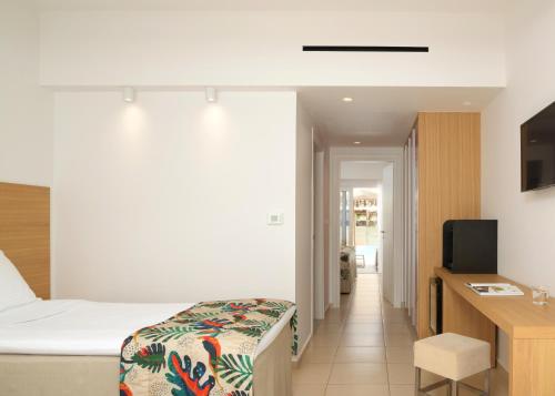 a hotel room with a bed and a television at High Beach Resort in Malia