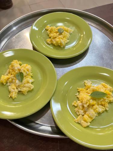 three green plates with food on a metal tray at Pousada Vila Parnaíba in Parnaíba
