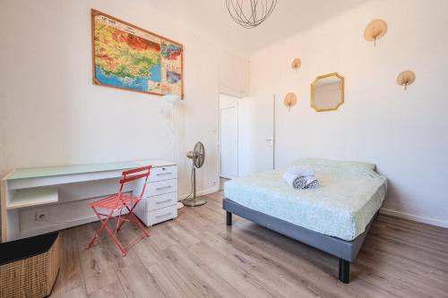 - une chambre avec un lit, un bureau et une chaise rouge dans l'établissement Appartement de Charme - Vue Panoramique Port, à La Seyne-sur-Mer
