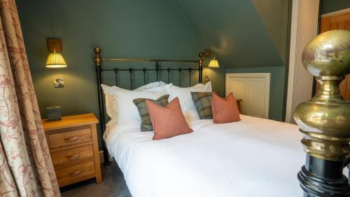 a bedroom with a bed with white sheets and pillows at Plato's in Kirkby Lonsdale