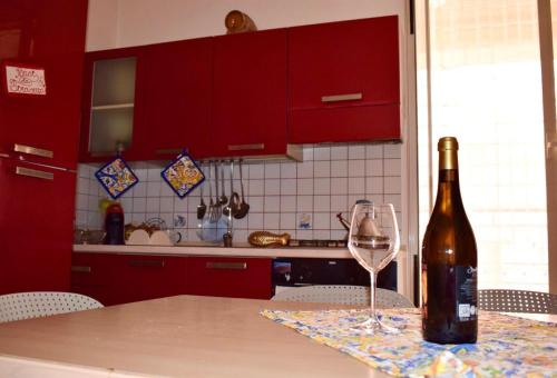 a bottle of wine sitting on a table with a wine glass at Conchiglia azzurra in Trappeto