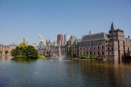 a city with buildings and a lake with a fountain at Park Centraal Den Haag, part of Sircle Collection in The Hague