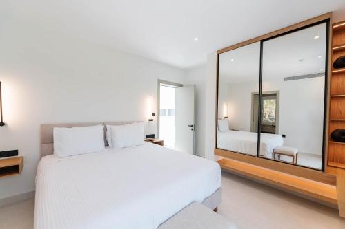 a bedroom with a large white bed and a mirror at Villa Lazareto in Kontokali