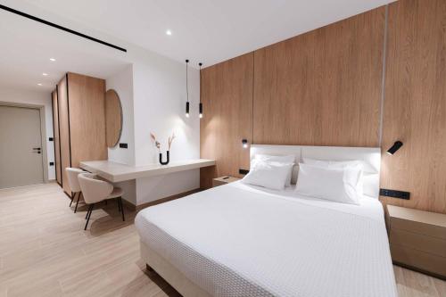 a bedroom with a large white bed and a desk at Villa Lazareto in Kontokali
