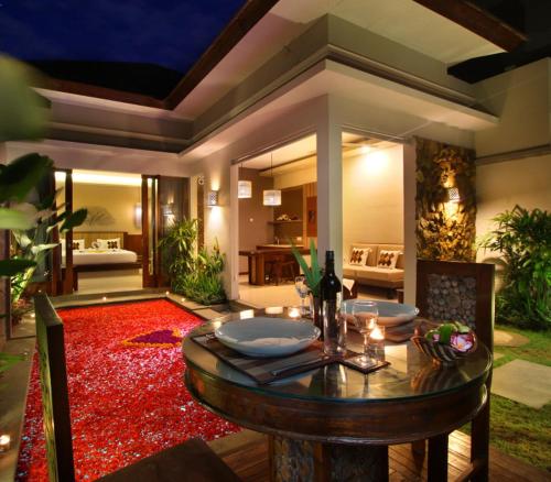 a dining room with a table and a red rug at Maharaja Villas Seminyak by Humus Hospitality in Kerobokan