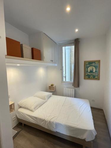 une chambre avec un lit blanc et une fenêtre dans l'établissement Bompard - Endoume - 2 Pièces - 5mn Vallon des Auffes, à Marseille