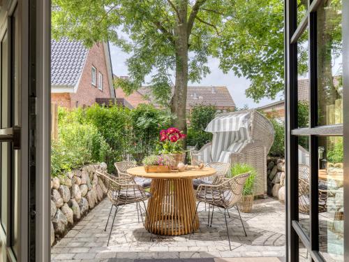 a patio with a table and chairs and a fence at Südwind's Deichperle in Westerland (Sylt)