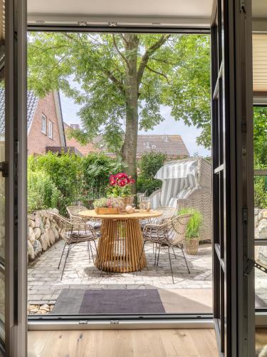 an open door to a patio with a table and chairs at Südwind's Deichperle in Westerland (Sylt)