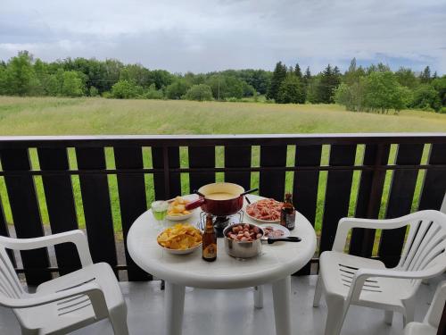 une table avec de la nourriture et des boissons sur un balcon dans l'établissement Studio au coeur de la montagne, à Thollon-les-Mémises