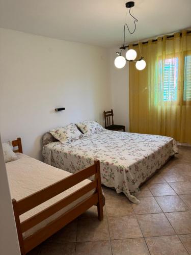 a bedroom with two beds and a bench in it at Apartmani Rakić in Ulcinj