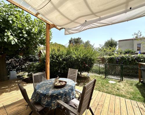 un patio avec une table et des chaises sur une terrasse dans l'établissement Le Cocon, Appartement pour 2 personnes à 5 minutes de la plage de l'Almanarre à Hyères, à Hyères