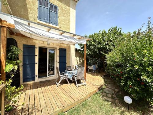 une terrasse en bois avec une table et des chaises dessus dans l'établissement Le Cocon, Appartement pour 2 personnes à 5 minutes de la plage de l'Almanarre à Hyères, à Hyères