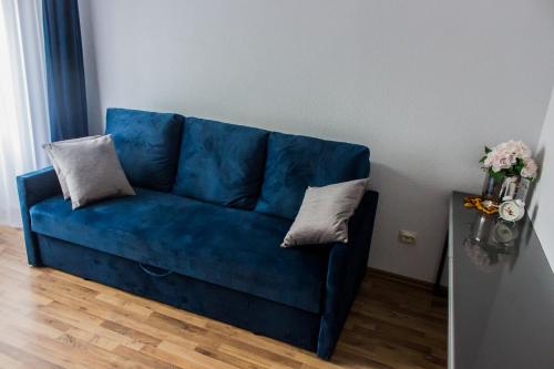 a blue couch with two pillows on it in a room at Apartament Amber 3 in Liepāja