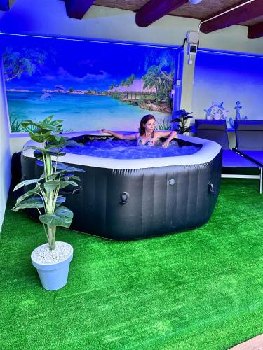 a woman in a hot tub in a room with green grass at Eduard Inn in Vulcan