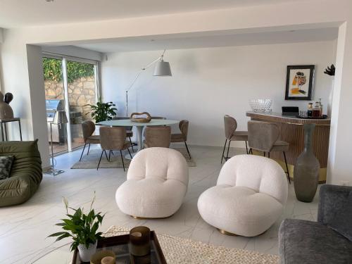 un salon avec deux chaises blanches et une table dans l'établissement Exclusif accès mer à Ramatuelle, à Ramatuelle